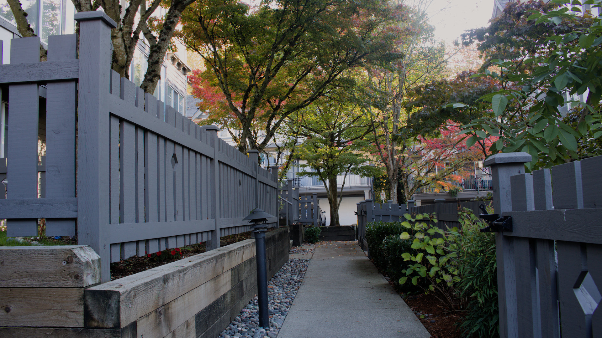 Landscaped pedestrian walkway bordered by fencing, trees and townhomes near 200 Street and 69 Avenue in Willoughby, Langley BC