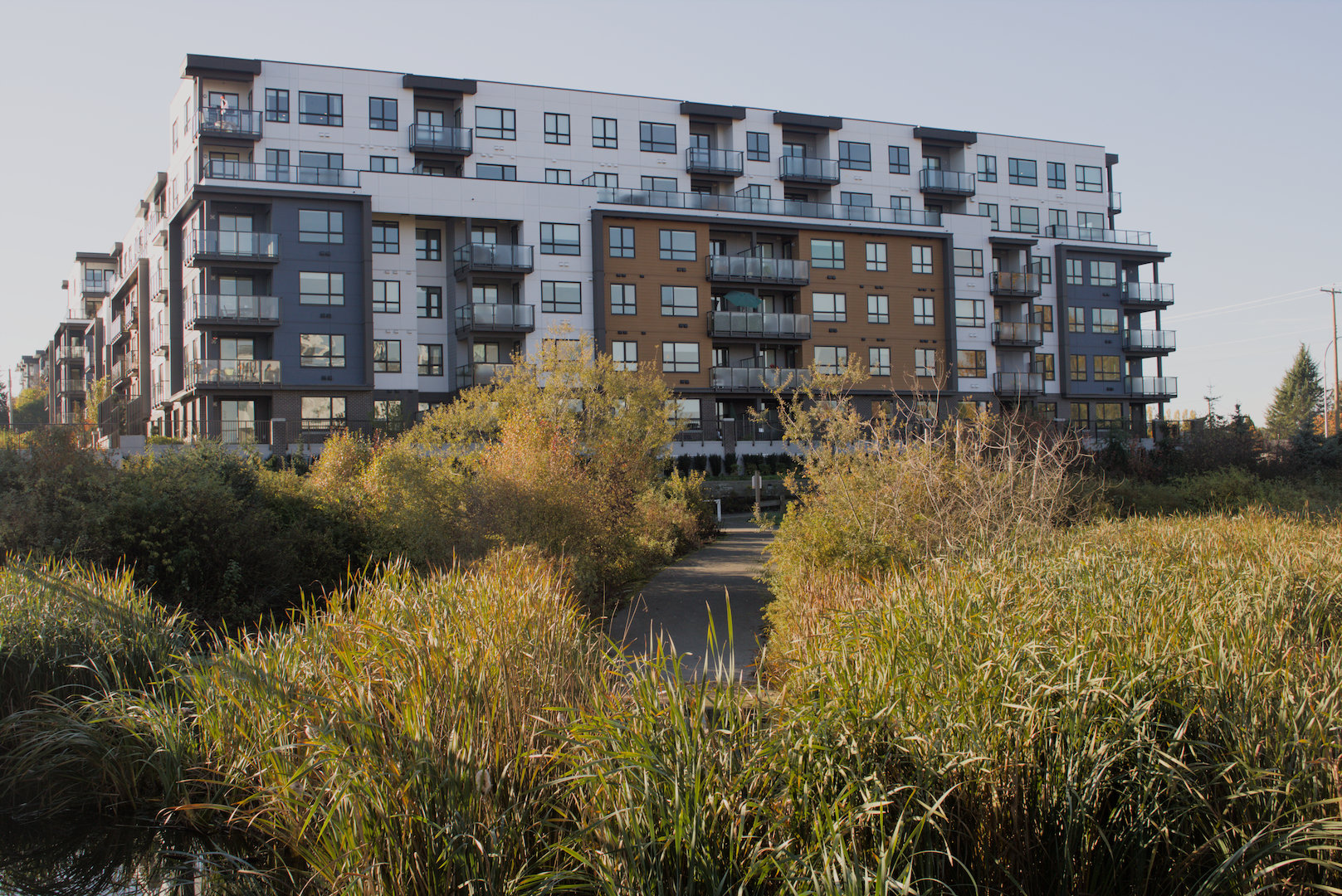 Modern condominium building surrounded by landscaped greenery in Willoughby, Langley BC
